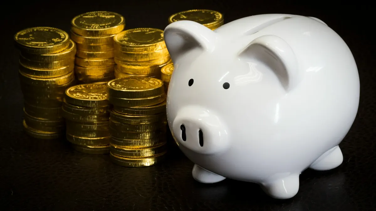 White piggy bank beside stacks of coins, budgeting for a cheap IPTV subscription in NZ